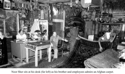 Noor Sher sits at his desk (far left).